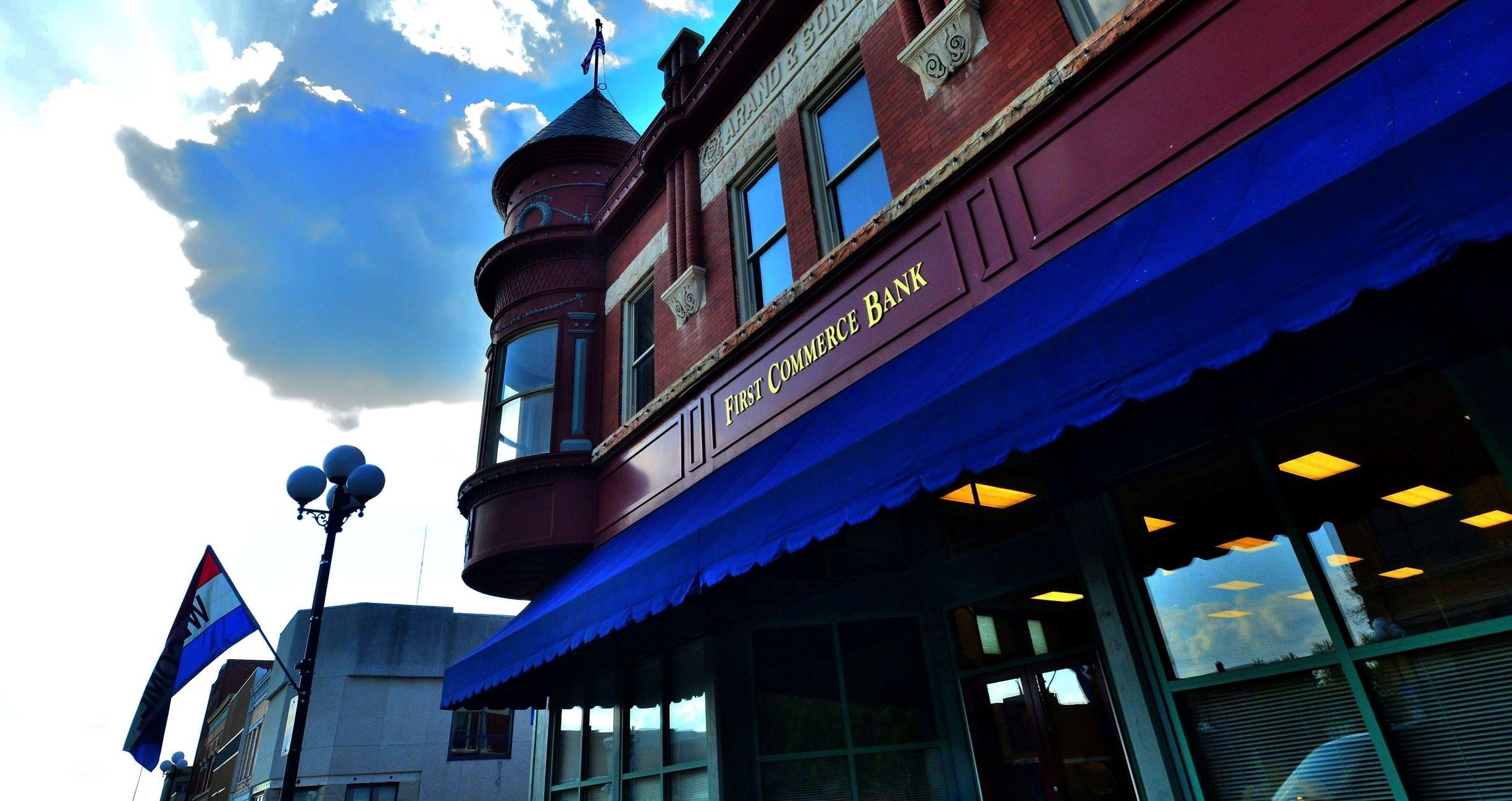 Front of First Commerce Bank with a cloudy Blue sky in the background